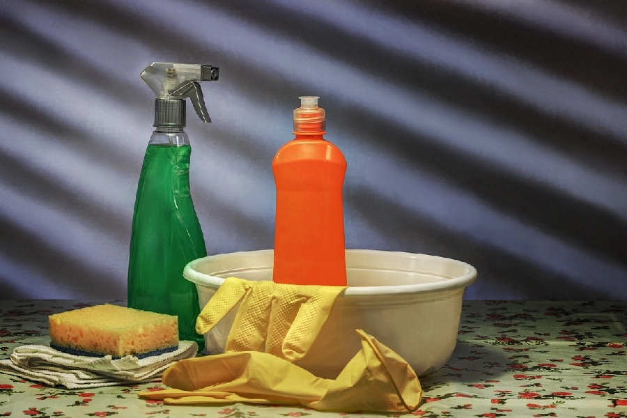 cleaning solution, spray bottle, rubber gloves, sponge, and a white containter for cleaning